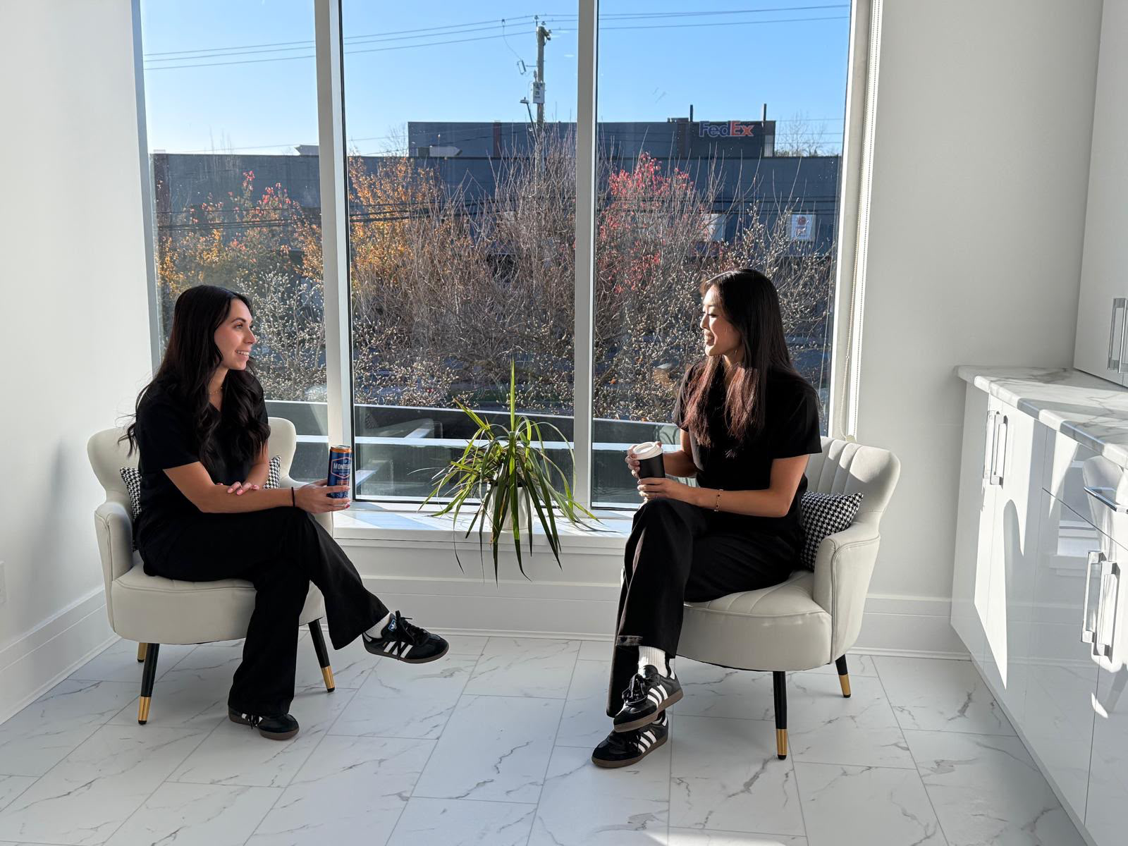 Two clinicians in conversation by a sunlit window at the Surrey clinic